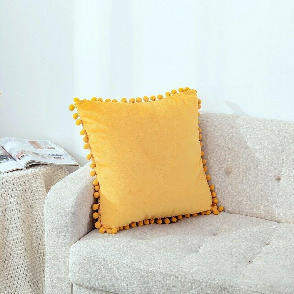 Elegant velvet cushion cover with pom pom details for a cozy living room